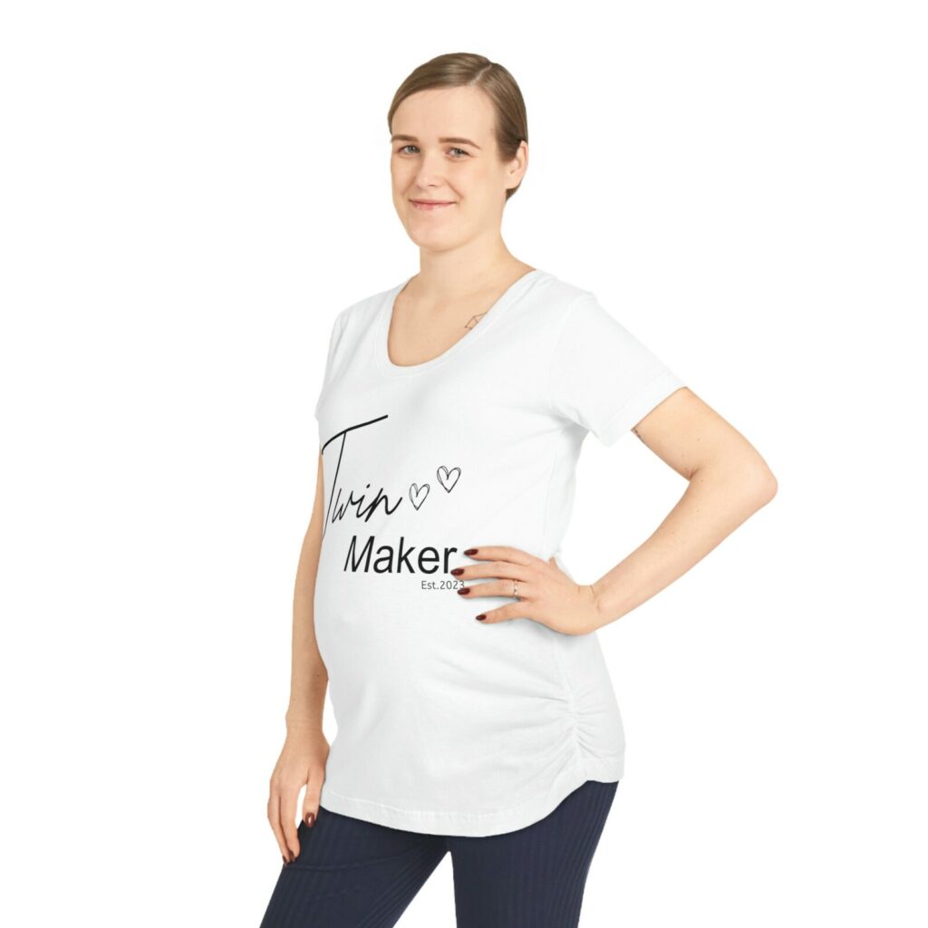 Pregnant women wearing a maternity shirt that says "Twin Maker"
