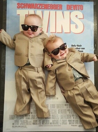 infant twin boys dressed up like the poster for the movie Twins