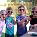 four kids wearing sunglasses summer shopping