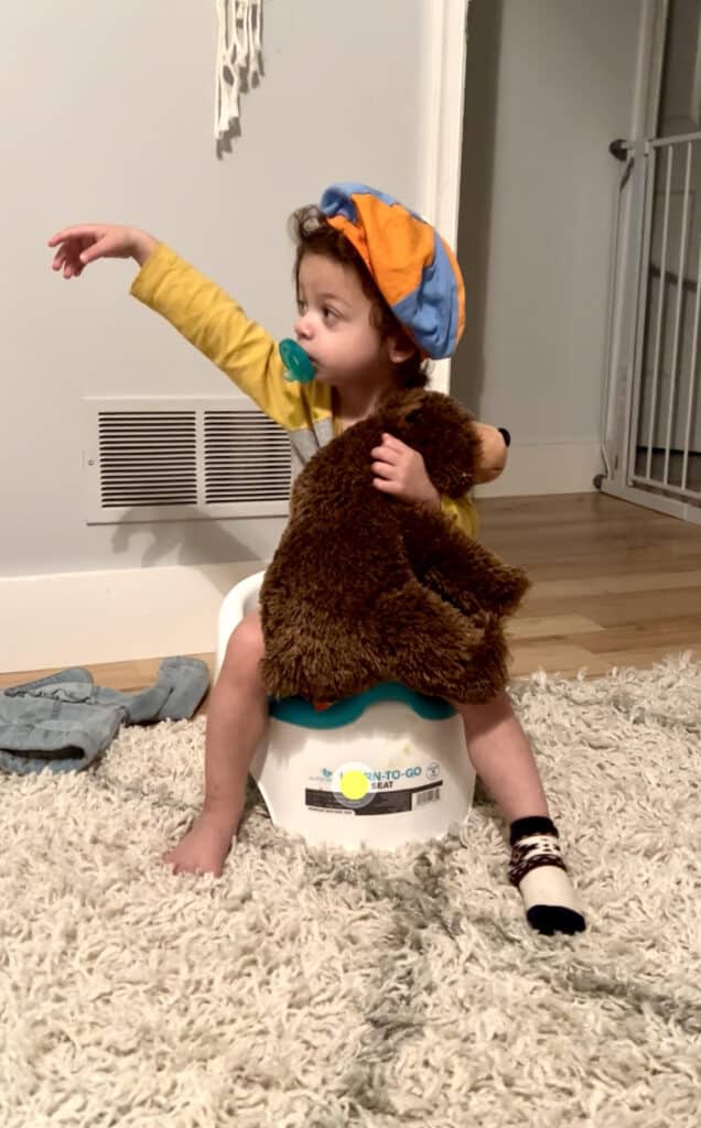 one twin sitting on a potty