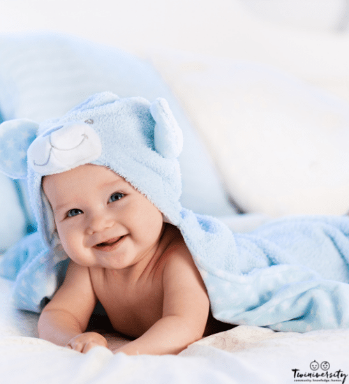 Baby on his belly with a hooded towel on him