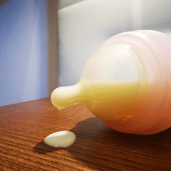 how many baby bottles do I need A baby bottle laying on a table and leaking