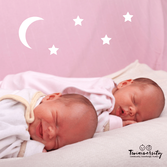 newborn twins sleeping on a white quilt with a pink background and white moon and stars